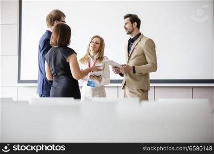 Business people discussing in seminar hall