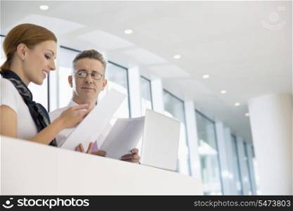 Business people discussing over documents in office