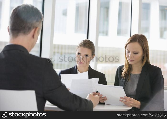 Business people discussing paperwork in office cafeteria