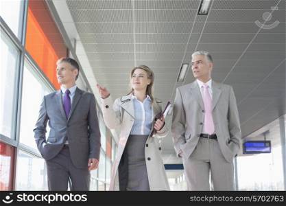 Business people discussing while walking on train platform