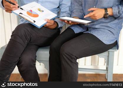 business people discussing with document using tablet at workplace