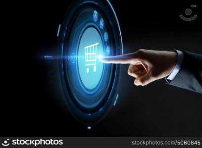 business, people, e-commerce and technology concept - close up of businessman hand pointing finger to shopping cart icon over black background. male hand pointing finger to shopping cart icon