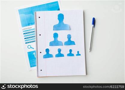 business, people, employment, career and hiring concept - close up of paper human shapes on notebook