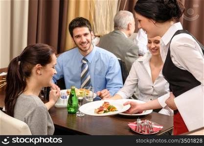 Business people enjoy lunch at the restaurant waitress serving woman