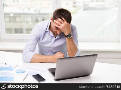 business, people, fail, paperwork and technology concept - businessman with laptop computer and papers working in office