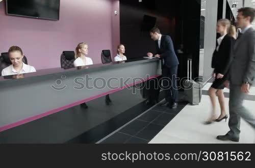 Business people filling in forms at reception front desk