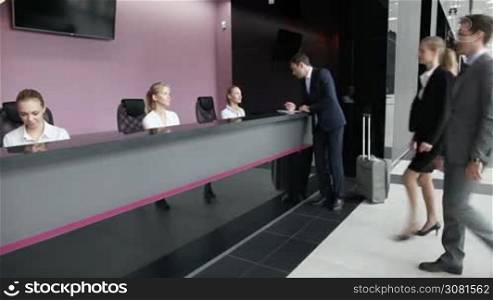 Business people filling in forms at reception front desk