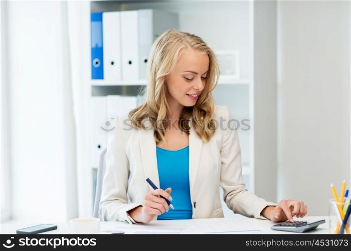 business, people, finance and accounting concept - smiling businesswoman with calculator counting and filling tax form at office
