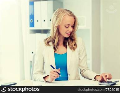 business, people, finance and accounting concept - smiling businesswoman with calculator counting and filling tax form at office. businesswoman with calculator counting at office
