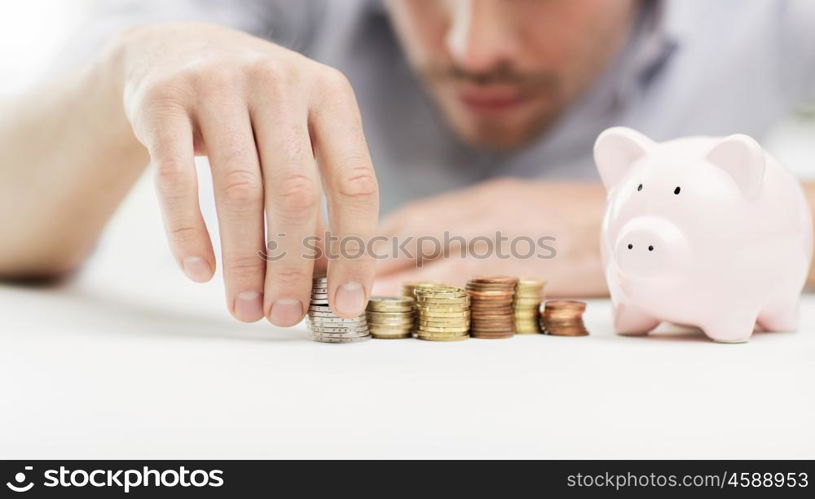 business, people, finances and money saving concept - close up of businessman with piggy bank and coins