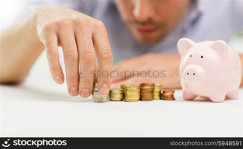business, people, finances and money saving concept - close up of businessman with piggy bank and coins