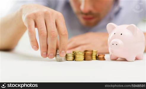business, people, finances and money saving concept - close up of businessman with piggy bank and coins