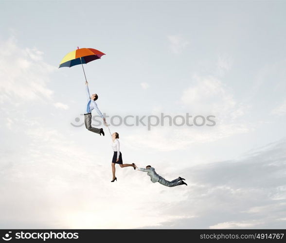 Business people flying in the sky on umbrella. Escape from office