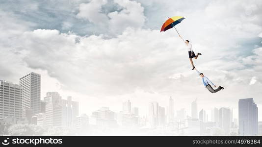 Business people flying in the sky on umbrella. Escape from office