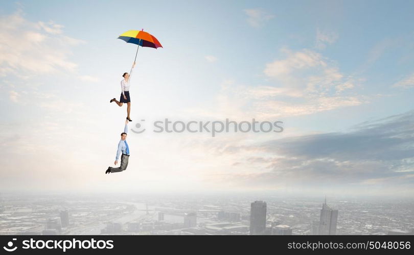 Business people flying in the sky on umbrella. Escape from office