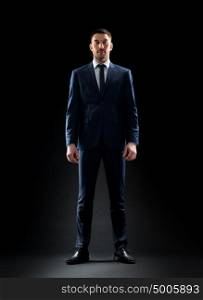 business, people, formal wear, fashion and office style concept - businessman in suit over black background. businessman in suit over black