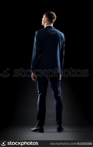 business, people, formalwear, fashion and office style concept - businessman in suit over black background. businessman in suit over black
