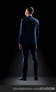 business, people, formalwear, fashion and office style concept - businessman in suit over black background. businessman in suit over black