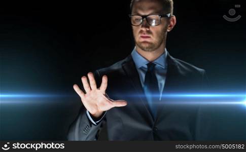 business, people, future technology and cyberspace concept - close up of businessman touching something imaginary over dark background and laser light. businessman touching something imaginary