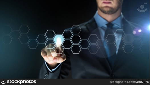 business, people, future technology, network and cyberspace concept - close up of businessman in suit touching virtual reality screen with hexagonal projection over dark background. businessman touching virtual hexagonal projection