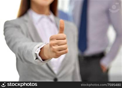 business people, gesture and success concept - close up of businesswoman showing thumbs up. close up of businesswoman showing thumbs up