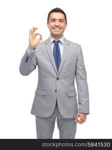 business, people, gesture and success concept - happy smiling businessman in suit ok hand sign