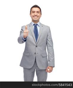 business, people, gesture and success concept - happy smiling businessman in suit showing thumbs up