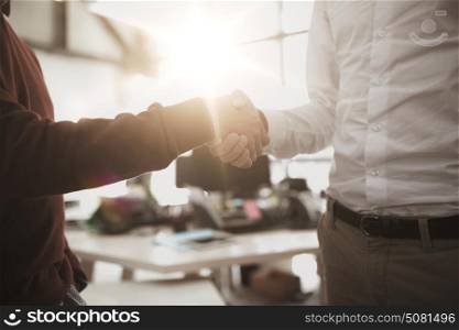 business, people, gesture, cooperation and partnership concept - businessmen making handshake at office. businessmen making handshake at office