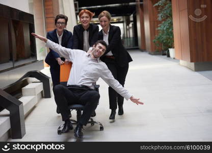 business people group at modern office indoors have fun and push office chair on corridor