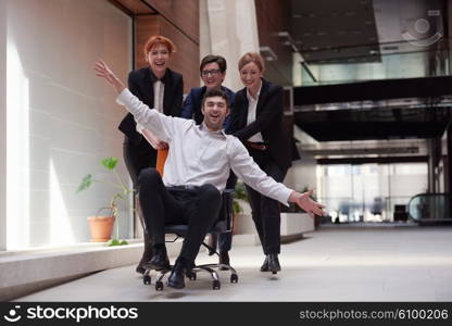 business people group at modern office indoors have fun and push office chair on corridor