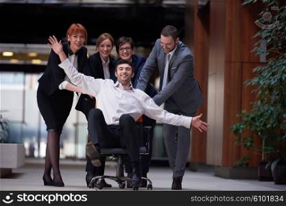 business people group at modern office indoors have fun and push office chair on corridor