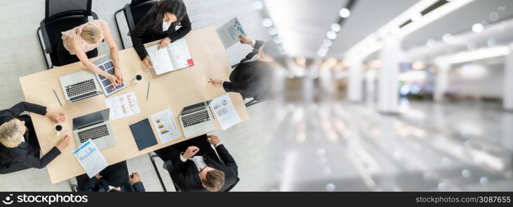 Business people group meeting shot from top widen view in office . Profession businesswomen, businessmen and office workers working in team conference with project planning document on meeting table .. Business people group meeting shot from top widen view