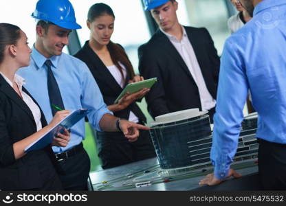 . business people group on meeting and presentation in bright modern office with construction engineer architect and worker looking building model and blueprint planbleprint plans