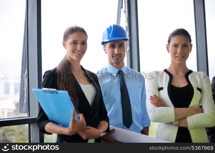 business people group on meeting and presentation in bright modern office with construction engineer architect and worker looking building model and blueprint plans