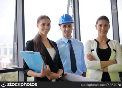 business people group on meeting and presentation in bright modern office with construction engineer architect and worker looking building model and blueprint plans