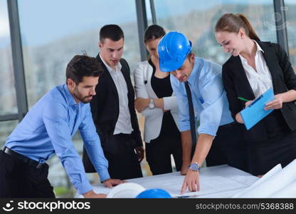 business people group on meeting and presentation in bright modern office with construction engineer architect and worker looking building model and blueprint plans