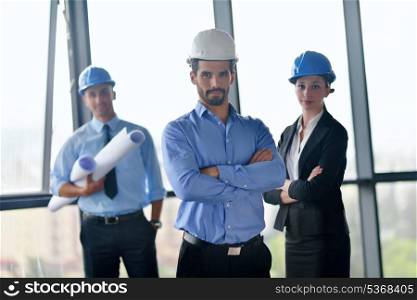 business people group on meeting and presentation in bright modern office with construction engineer architect and worker looking building model and blueprint plans