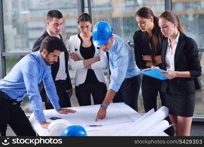 business people group on meeting and presentation in bright modern office with construction engineer architect and worker looking building model and blueprint planbleprint plans