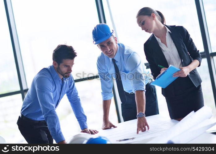 business people group on meeting and presentation in bright modern office with construction engineer architect and worker looking building model and blueprint planbleprint plans