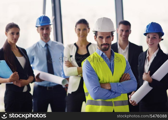 business people group on meeting and presentation in bright modern office with construction engineer architect and worker looking building model and blueprint planbleprint plans