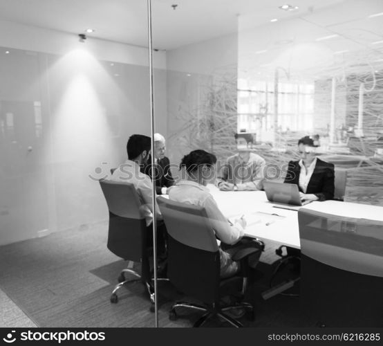 business people group on meeting at modern startup office, senior man as leader looking on tablet and laptop presentation of his team