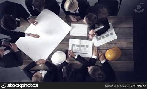 Business people group on meeting with construction engineer architect looking at building blueprint