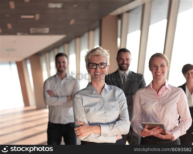 business people group standing together as team by window in modern bright office interior