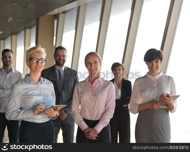 business people group standing together as team by window in modern bright office interior