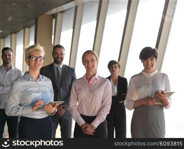 business people group standing together as team by window in modern bright office interior