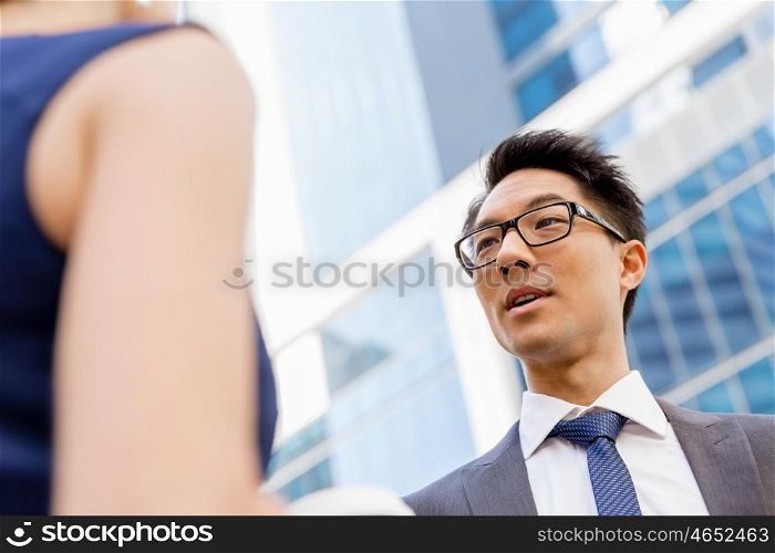 Business people having a talk while walking in a businesss district. Two colleagues walking together in a city
