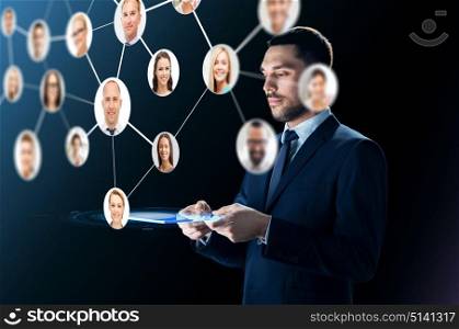 business, people, headhunting, communication and modern technology concept - businessman in suit working with transparent tablet pc computer and contacts network over black background. businessman with tablet pc and contacts network