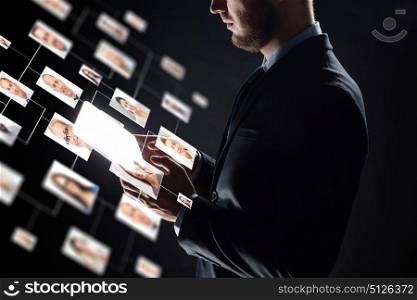 business, people, hiring, employment and future technology concept - close up of businessman with transparent tablet pc computer and contact icons over black background. close up of businessman with transparent tablet pc