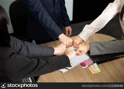 Business people join punching fists bump hands as team their meeting, Giving touch punch together of power teamwork, Business group winning successful company achieving goals with determined staff
