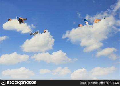 Business people lying on clouds. Image of businesspeople lying on clouds with tablet pc